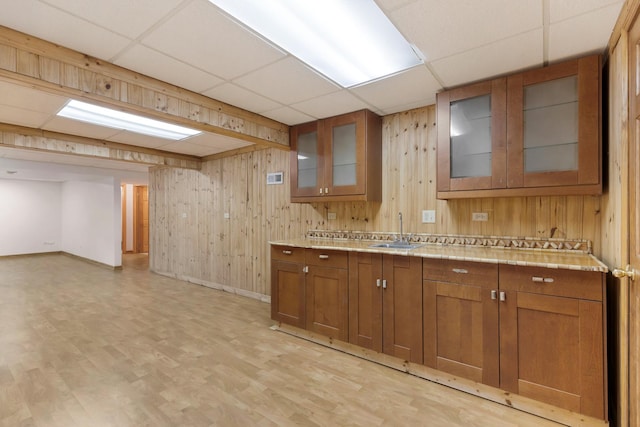 775 Harmon Blvd, Hoffman Estates, IL 60169 - kitchen with a drop ceiling, brown cabinets, wooden walls, light wood-style floors, and glass insert cabinets