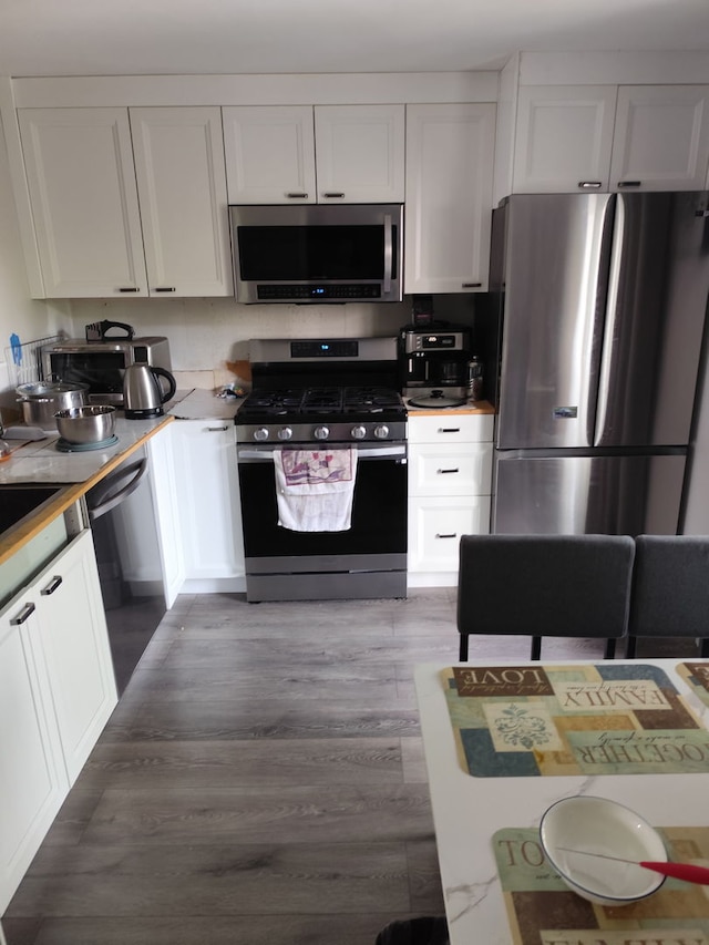 438 Meadow Hill Ln, Round Lake Beach, IL 60073 - kitchen with appliances with stainless steel finishes, white cabinets, light countertops, and wood finished floors