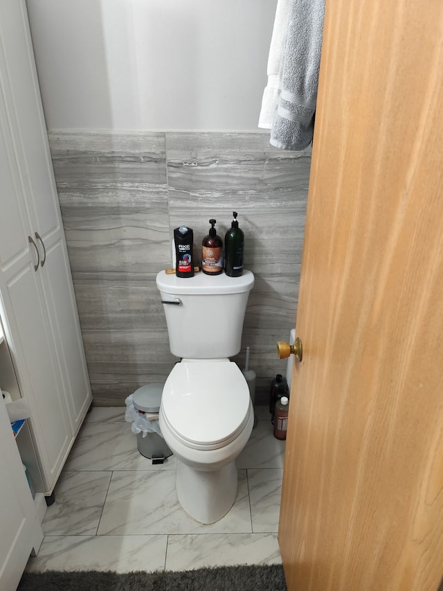 438 Meadow Hill Ln, Round Lake Beach, IL 60073 - bathroom with marble look tile flooring, tile walls, and a wainscoted wall