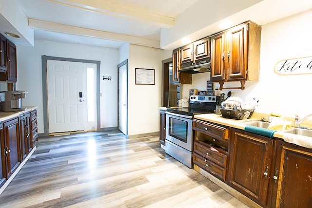 401 N 2nd Ave, Chenoa, IL 61726 - kitchen featuring stainless steel range with electric stovetop, under cabinet range hood, light wood-type flooring, and light countertops