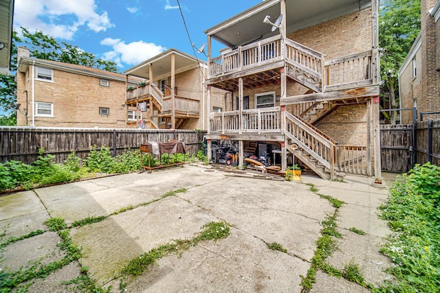 5567 W Gladys Ave, Chicago, IL 60644 - rear view of house featuring brick siding, a fenced backyard, a patio, and stairs