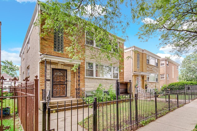 5567 W Gladys Ave, Chicago, IL 60644 - view of front facade with a fenced front yard, a gate, and stone siding