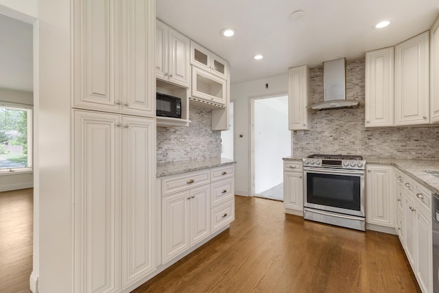 323 S Prindle Ave, Arlington Heights, IL 60004 - kitchen featuring stainless steel gas range oven, wall chimney range hood, black microwave, dark wood-type flooring, and backsplash