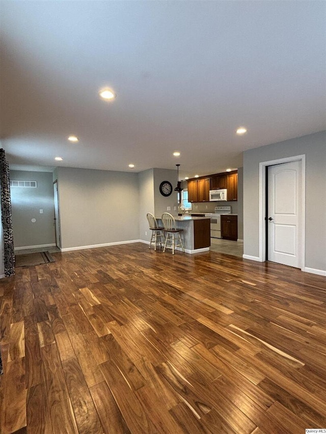 802 W Main St, La Harpe, IL 61450 - unfurnished living room featuring dark wood-style flooring and recessed lighting