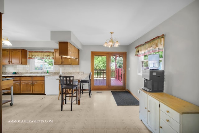 506 S 5th St, Malta, IL 60150 - kitchen featuring dishwasher, decorative backsplash, brown cabinets, light countertops, and a chandelier