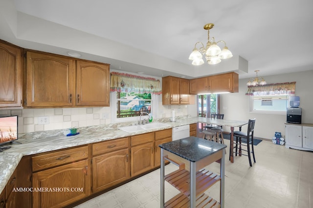 506 S 5th St, Malta, IL 60150 - kitchen with light floors, a chandelier, backsplash, and brown cabinetry