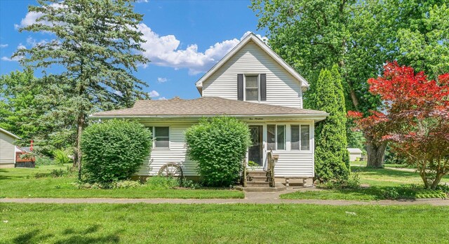 519 S 4th St, Fairbury, IL 61739 - view of front facade with a front yard, entry steps, a shingled roof, and a sunroom