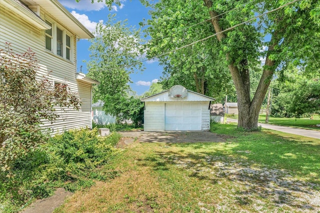 519 S 4th St, Fairbury, IL 61739 - view of green lawn featuring an outbuilding, a detached garage, and driveway