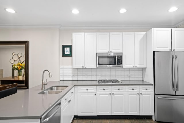 1801 W Diversey Pkwy Unit 36, Chicago, IL 60614 - kitchen featuring appliances with stainless steel finishes, a peninsula, crown molding, white cabinets, and decorative backsplash