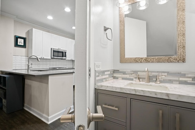 1801 W Diversey Pkwy Unit 36, Chicago, IL 60614 - bathroom featuring backsplash, wood finished floors, vanity, crown molding, and recessed lighting