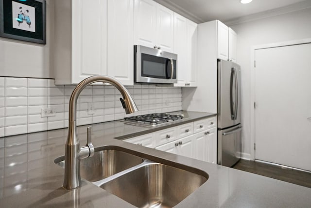1801 W Diversey Pkwy Unit 36, Chicago, IL 60614 - kitchen featuring stainless steel appliances, white cabinets, backsplash, dark countertops, and ornamental molding
