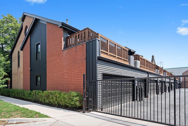 1801 W Diversey Pkwy Unit 36, Chicago, IL 60614 - view of side of home featuring an attached garage, brick siding, a balcony, and concrete driveway