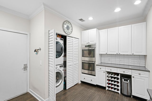 1801 W Diversey Pkwy Unit 36, Chicago, IL 60614 - kitchen featuring estacked washer and dryer, double oven, ornamental molding, white cabinets, and dark wood-style flooring