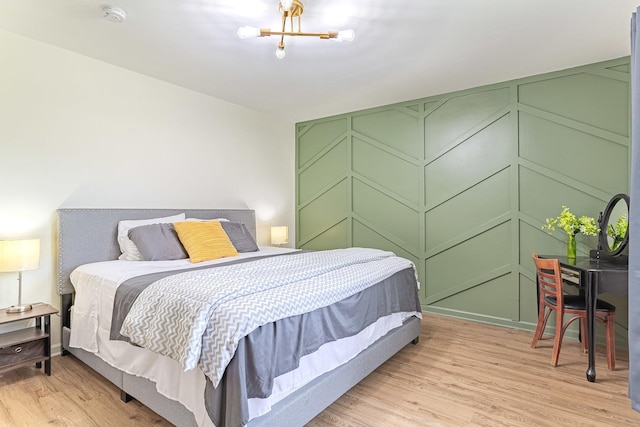 7559 Kingsbury Dr, Hanover Park, IL 60133 - bedroom featuring light wood-style flooring, a chandelier, and a decorative wall