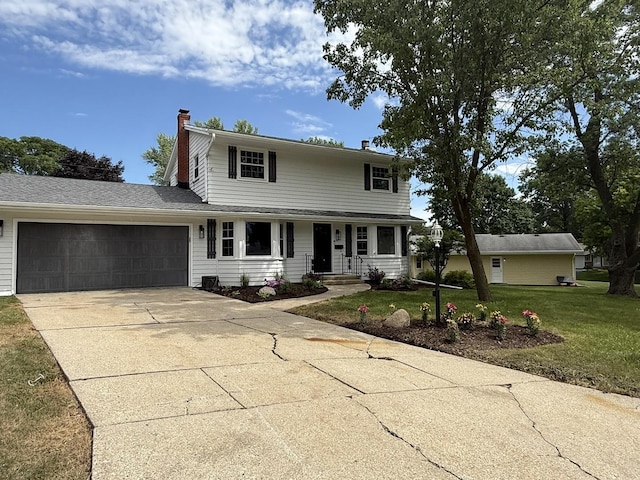 3814 Abbotsford Rd, Rockford, IL 61107 - traditional home featuring a chimney, driveway, an attached garage, a front yard, and covered porch