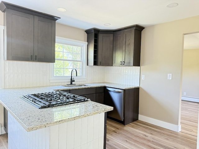 3814 Abbotsford Rd, Rockford, IL 61107 - kitchen featuring stovetop, stainless steel dishwasher, light stone counters, light wood-style floors, and decorative backsplash