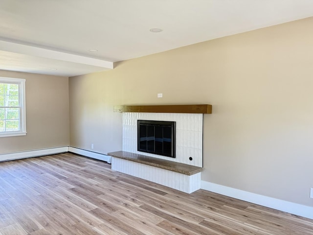 3814 Abbotsford Rd, Rockford, IL 61107 - unfurnished living room with wood finished floors, a baseboard heating unit, and a glass covered fireplace