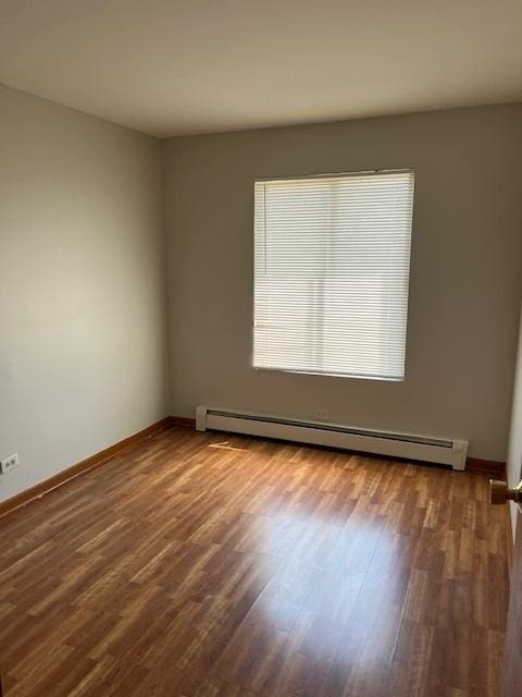 291 Gregory St Unit 6, Aurora, IL 60504 - empty room with baseboard heating and wood finished floors