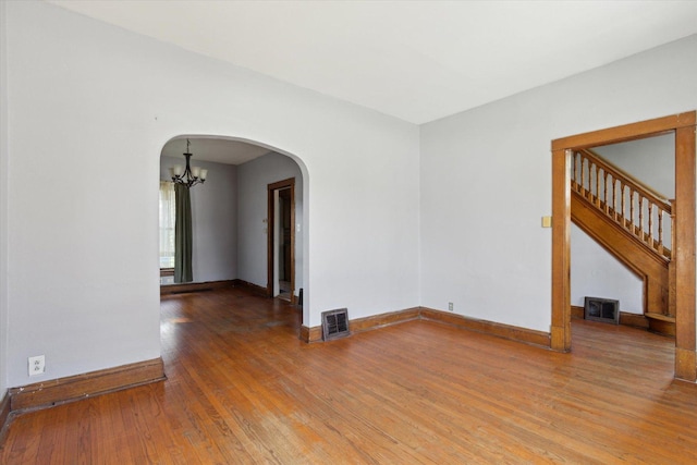 1304 E 4th St, Sterling, IL 61081 - unfurnished room with arched walkways, hardwood / wood-style flooring, a chandelier, and stairway