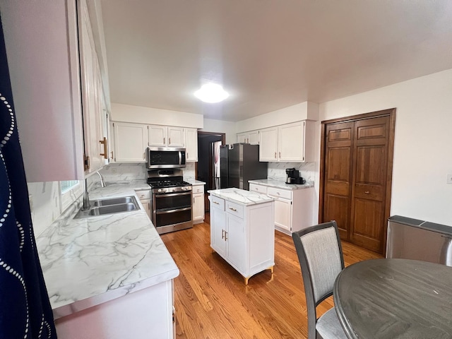 1970 Division St, Saint Charles, IL 60174 - kitchen featuring stainless steel appliances, light wood finished floors, white cabinets, backsplash, and a center island