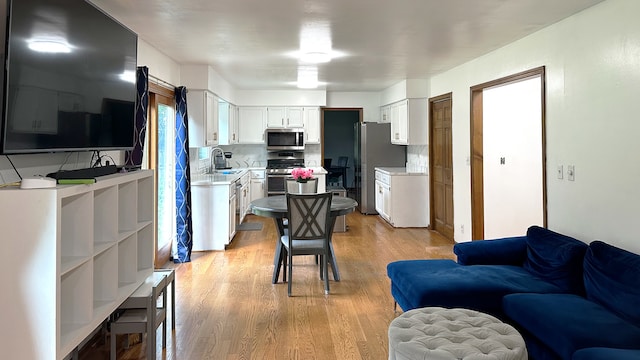 1970 Division St, Saint Charles, IL 60174 - kitchen featuring stainless steel appliances, light countertops, light wood-style floors, open floor plan, and white cabinets