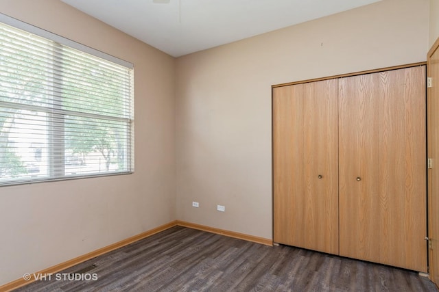 2501 Park Ridge Ct Unit 2501, Crest Hill, IL 60403 - unfurnished bedroom featuring a closet, dark wood-type flooring, and multiple windows