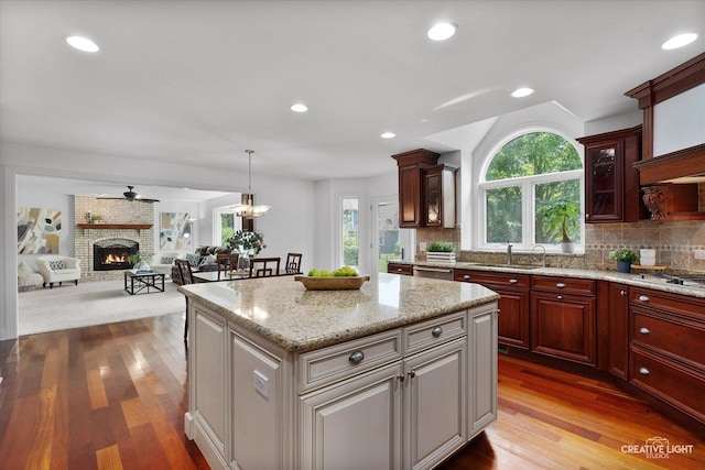 1112 Saratoga Ct, Naperville, IL 60564 - kitchen featuring healthy amount of natural light, wood finished floors, decorative backsplash, a brick fireplace, and recessed lighting