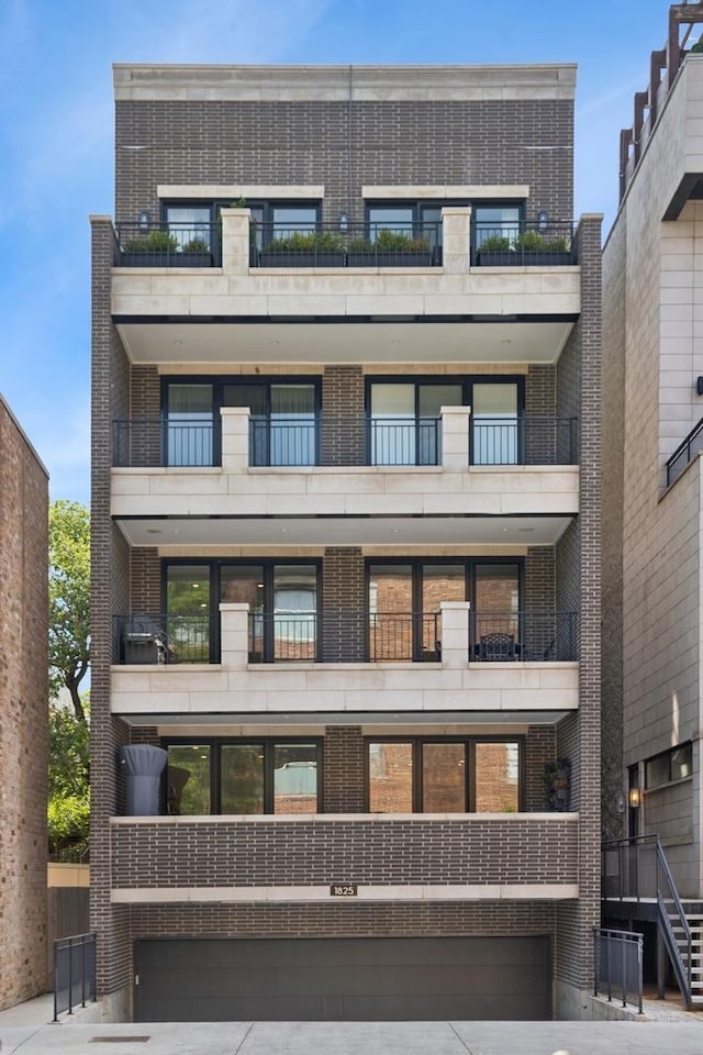 1825 N Halsted St Unit 2, Chicago, IL 60614 - view of front of home featuring brick siding, a balcony, and driveway