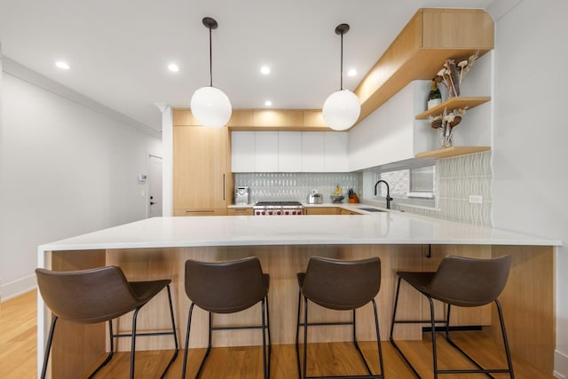1825 N Halsted St Unit 2, Chicago, IL 60614 - kitchen featuring light countertops, backsplash, a peninsula, light wood-style floors, and modern cabinets