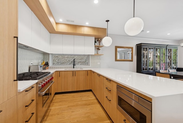 1825 N Halsted St Unit 2, Chicago, IL 60614 - kitchen featuring stainless steel appliances, a peninsula, light countertops, tasteful backsplash, and recessed lighting