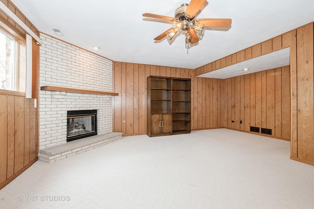 15309 S 73rd Ave Unit 15309, Orland Park, IL 60462 - unfurnished living room featuring wood walls, carpet flooring, a brick fireplace, and a ceiling fan