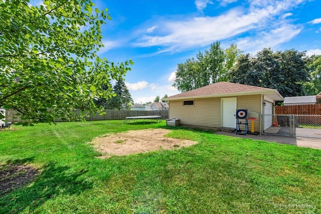 26 W Pine Ave, Cortland, IL 60112 - fenced backyard with a trampoline, a gate, and a garage