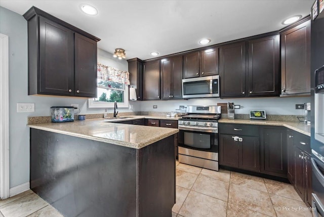 26 W Pine Ave, Cortland, IL 60112 - kitchen featuring stainless steel appliances, dark brown cabinetry, recessed lighting, a peninsula, and light stone countertops