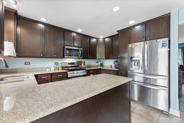 26 W Pine Ave, Cortland, IL 60112 - kitchen with appliances with stainless steel finishes, dark brown cabinetry, recessed lighting, light tile patterned floors, and light stone countertops