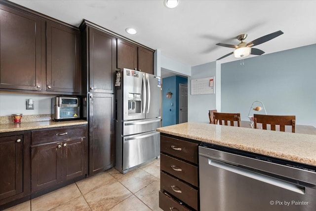26 W Pine Ave, Cortland, IL 60112 - kitchen featuring appliances with stainless steel finishes, ceiling fan, dark brown cabinetry, light tile patterned flooring, and light stone counters