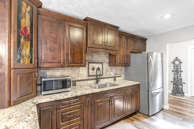 7 Walnut Dr, North Aurora, IL 60542 - kitchen featuring stainless steel appliances, backsplash, light wood finished floors, light stone countertops, and recessed lighting