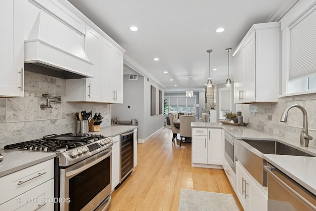 6848 N Oriole Ave, Chicago, IL 60631 - kitchen featuring appliances with stainless steel finishes, wine cooler, custom range hood, white cabinets, and light countertops
