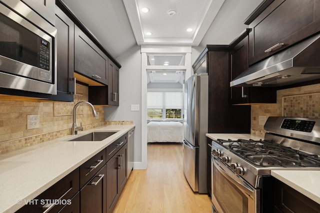 6848 N Oriole Ave, Chicago, IL 60631 - kitchen featuring stainless steel appliances, under cabinet range hood, light wood-type flooring, light countertops, and dark brown cabinets