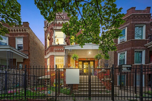 1916 N Lowell Ave, Chicago, IL 60639 - view of front facade with a fenced front yard, a gate, and brick siding