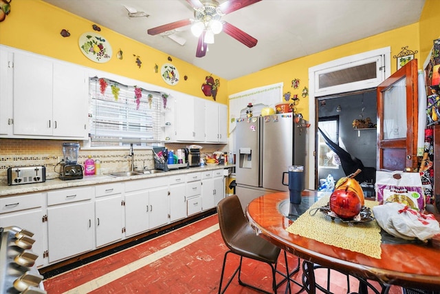 1916 N Lowell Ave, Chicago, IL 60639 - kitchen with ceiling fan, stainless steel refrigerator with ice dispenser, light countertops, white cabinetry, and backsplash
