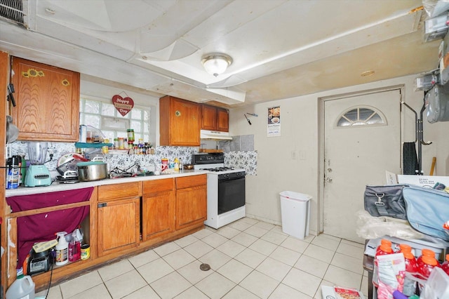 1916 N Lowell Ave, Chicago, IL 60639 - kitchen featuring white gas stove, under cabinet range hood, brown cabinetry, and light countertops