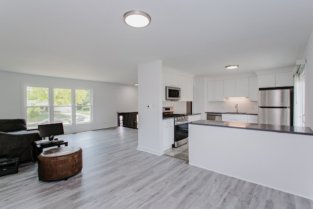 815 Concord Cv, Hoffman Estates, IL 60192 - kitchen featuring stainless steel appliances, open floor plan, light wood finished floors, and dark countertops