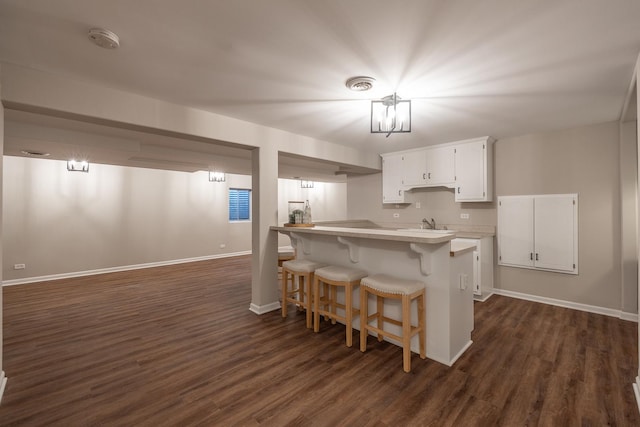 25030 Round Barn Rd, Plainfield, IL 60585 - kitchen with dark wood-style floors, white cabinets, a kitchen breakfast bar, and light countertops