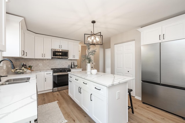 25030 Round Barn Rd, Plainfield, IL 60585 - kitchen featuring appliances with stainless steel finishes, tasteful backsplash, light wood-style flooring, a kitchen island, and a chandelier