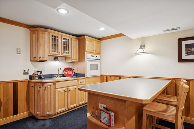 1219 N Lakeview Ct, Palatine, IL 60067 - kitchen with oven, a breakfast bar area, wainscoting, glass insert cabinets, and recessed lighting