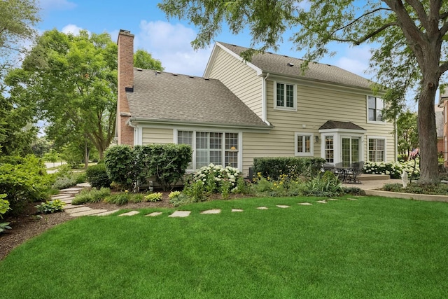 1219 N Lakeview Ct, Palatine, IL 60067 - back of property featuring a patio area, a chimney, a yard, and a shingled roof