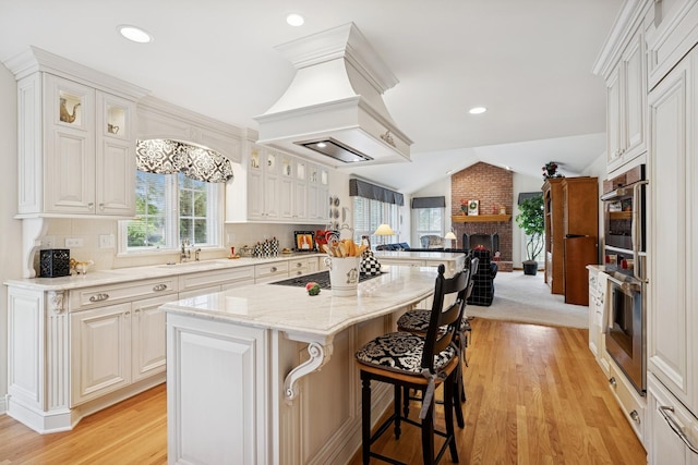 1219 N Lakeview Ct, Palatine, IL 60067 - kitchen with open floor plan, stainless steel oven, light wood-type flooring, a kitchen breakfast bar, and a center island