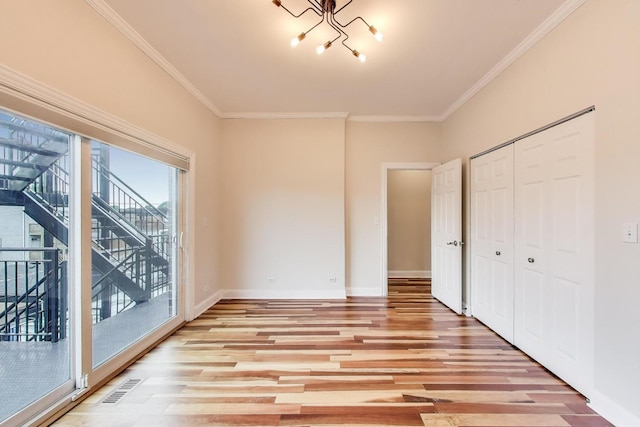 1634 N Wolcott Ave Unit 3, Chicago, IL 60622 - unfurnished bedroom with access to outside, a chandelier, light wood-style floors, crown molding, and a closet