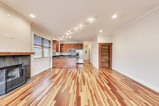 1634 N Wolcott Ave Unit 3, Chicago, IL 60622 - unfurnished living room with crown molding, a tile fireplace, light wood finished floors, recessed lighting, and track lighting