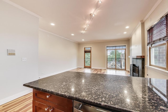 1634 N Wolcott Ave Unit 3, Chicago, IL 60622 - kitchen with light wood finished floors, ornamental molding, a tiled fireplace, recessed lighting, and dark stone countertops